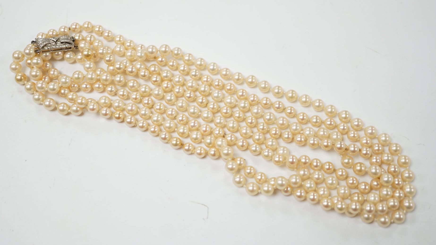 A double strand simulated pearl necklace, with diamond cluster set white metal clasp, 90cm. Condition - fair